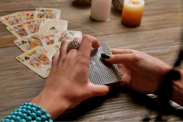 Cartomancie 32 cartes: Main féminine tirant une carte de tarot de la pile